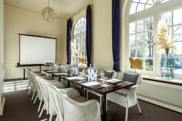 Ein Zimmer im A-ROSA Travemünde mit einem Tisch und Stühlen.