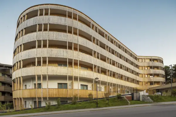 Ein Gebäude mit Balkonen und einer Straße im Vordergrund.