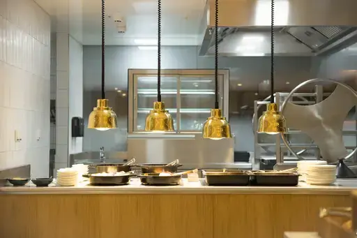 Küche mit hängenden Pfannen an der Decke und sichtbarem Waschbecken.