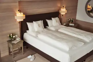 Ein Bett mit weißen Laken und Kissen.
