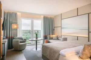 Hotelzimmer mit Bett, Tisch und Stühlen