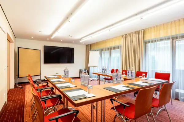 Ein Zimmer im A-ROSA Travemünde mit einem Tisch und Stühlen.
