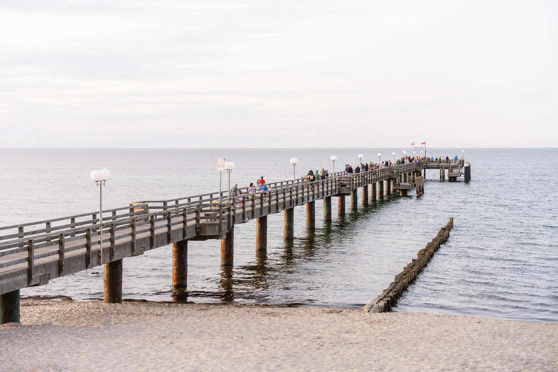 Eine Gruppe von Menschen auf einem Pier im Freien.