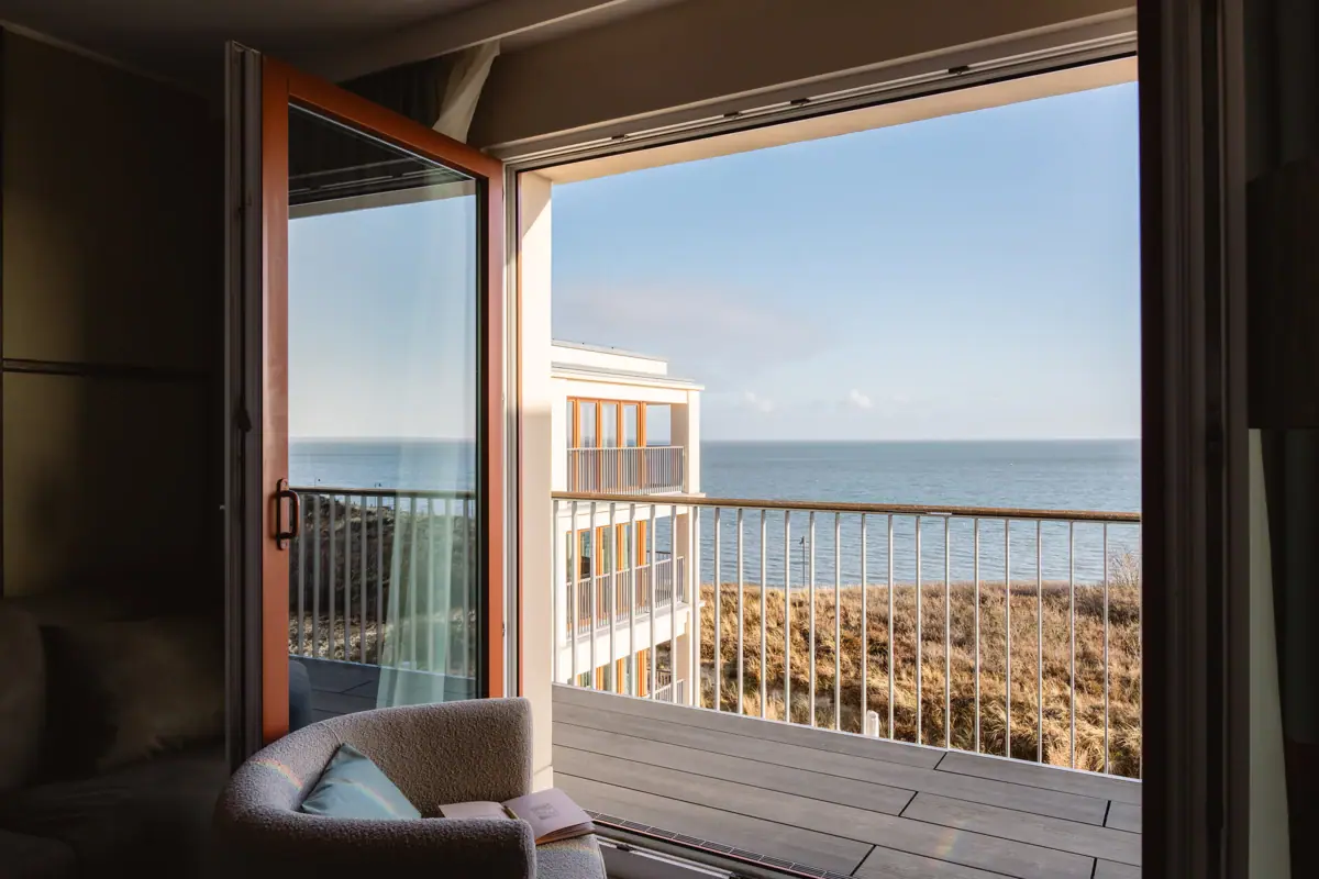 Ein Zimmer mit Balkon und Blick auf den Ozean.