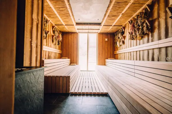 Eine Sauna mit Holzbänken und einer Tür im A-ROSA Hotel Sylt.