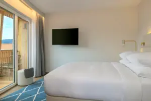 Bett mit Flachbildfernseher an der Wand in einem stilvollen Zimmer.