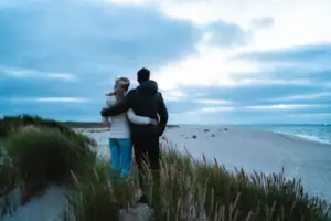 Ein Mann und eine Frau stehen am Strand.