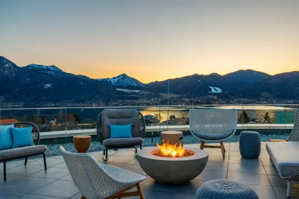 Feuerstelle mit Stühlen und Blick auf Berge im Hintergrund