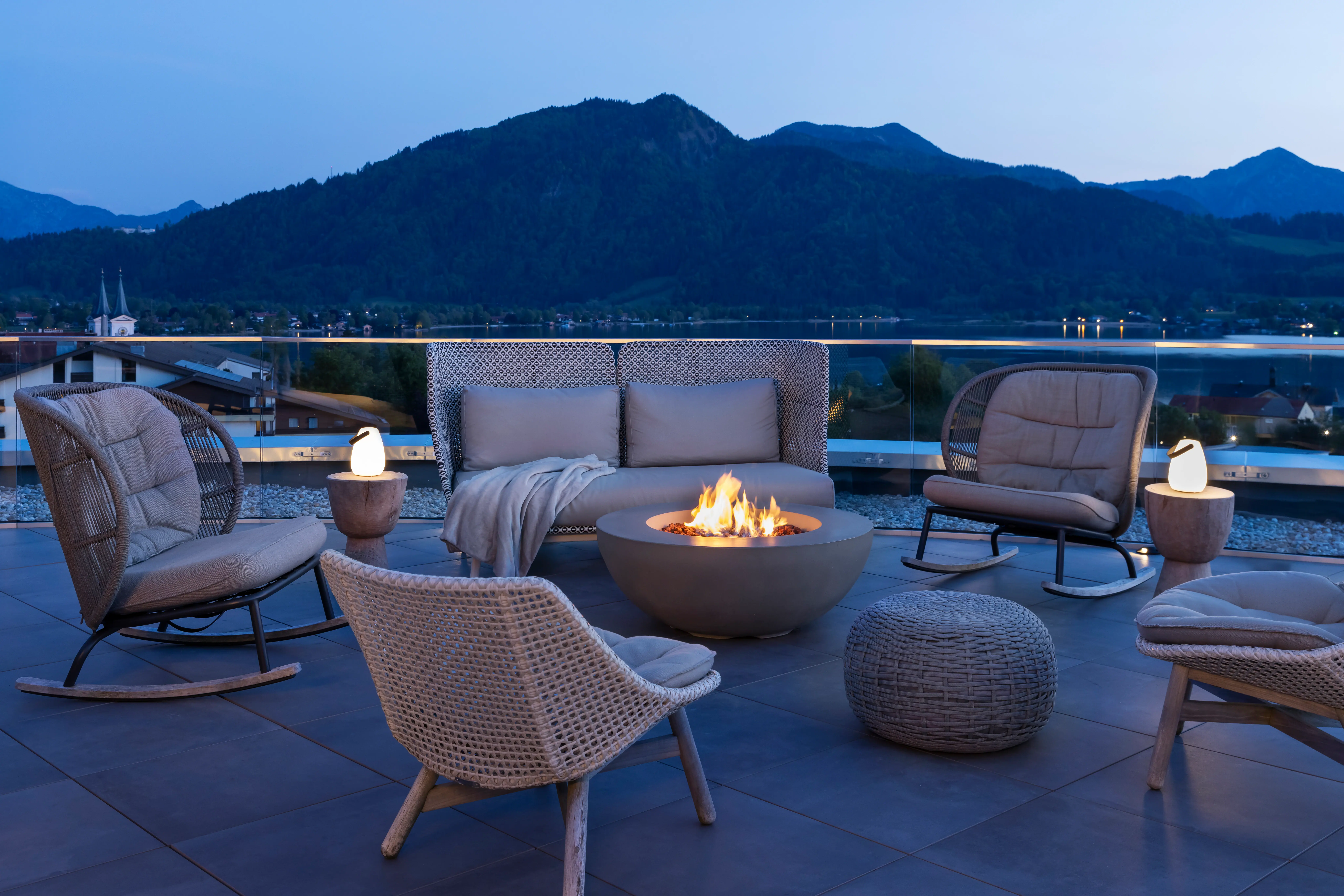 Eine Terrasse mit einem Feuerstelle und Stühlen auf einem Balkon.