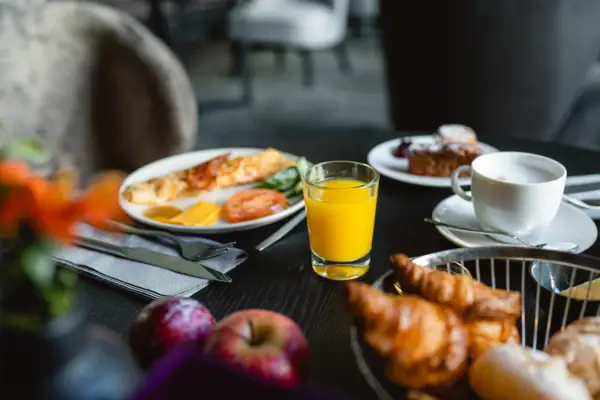Ein Teller mit Frühstück und ein Glas Saft auf einem Tisch.