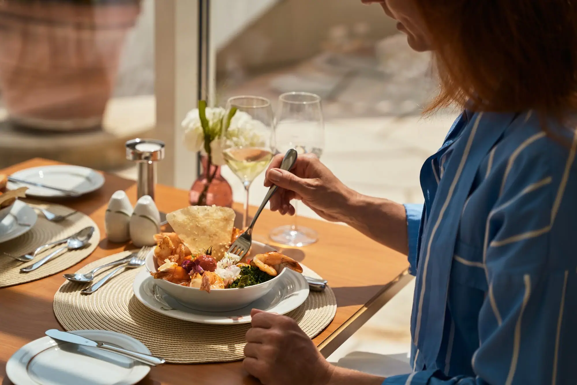 Frau isst eine Schüssel mit Essen.
