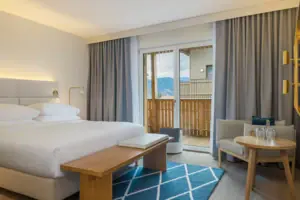 Ein Zimmer mit einem Bett, einem Tisch und Stühlen.