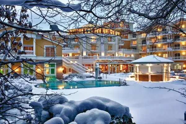 Ein Gebäude mit einem Pool im Schnee, umgeben von winterlicher Landschaft.