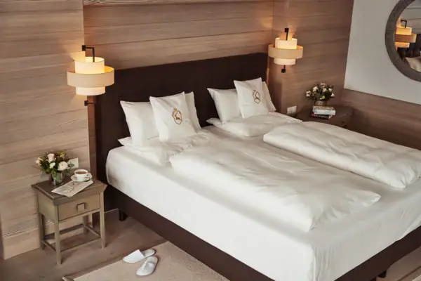 Ein Bett mit weißen Laken und Kissen.
