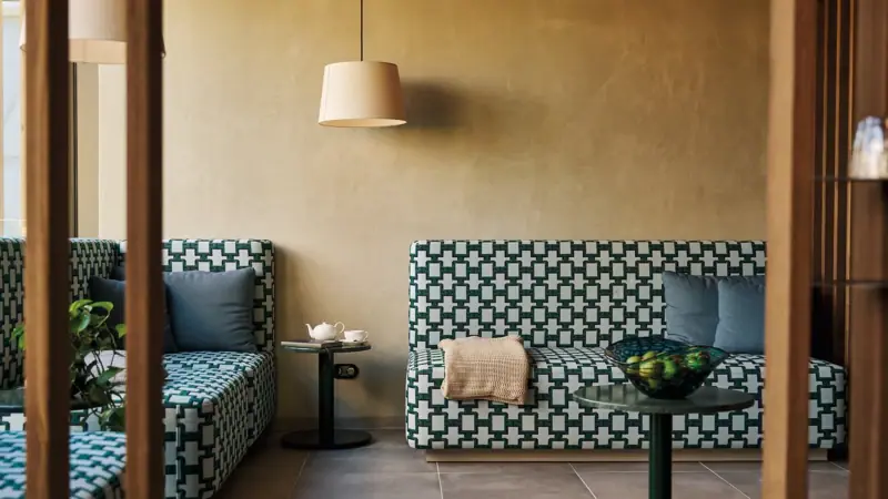 Sofas und ein Tisch in einem Raum mit Vase und Lampe.