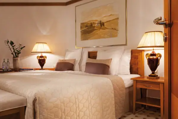 Ein Bett mit Lampen und einem Gemälde an der Wand.