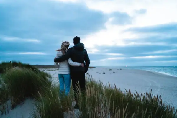 Ein Mann und eine Frau stehen am Strand.