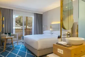 Schlafzimmer mit großem Bett und Spiegel.