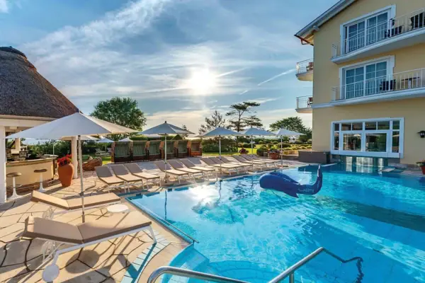 Ein Außenpool mit Liegestühlen im Wellnesshotel Kühlungsborn