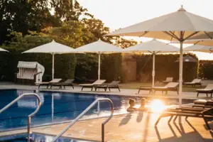 Ein Außenpool mit Sonnenschirmen und Liegestühlen.