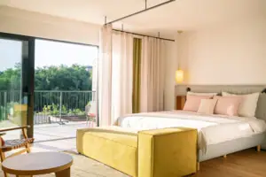 Schlafzimmer mit Bett und Couch, elegant eingerichtet mit Kissen und Bettwäsche.