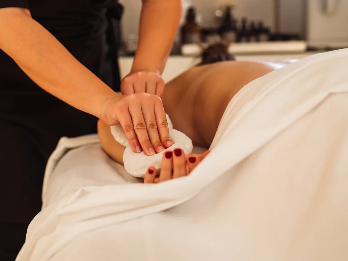 Eine Frau liegt auf einer Liege und erhält eine Massage im Thurnher’s Alpenhof.