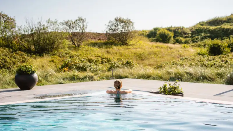 Eine Frau schwimmt in dem Outdoor-Pool im A-ROSA Hotel Sylt.