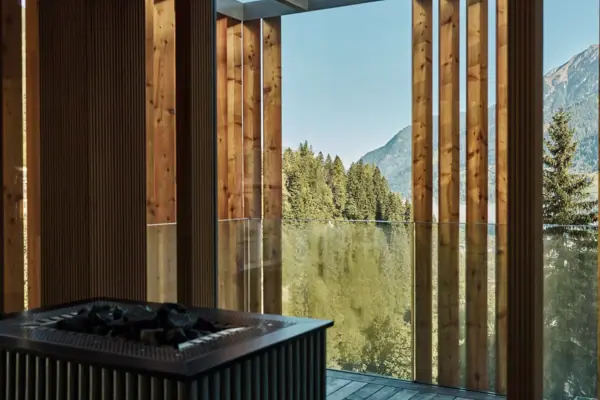 Sauna mit Aufgussschale und Bäumen im Hintergrund