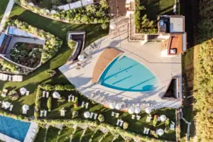 Ein Swimmingpool, umgeben von Rasenflächen und Pflanzen.
