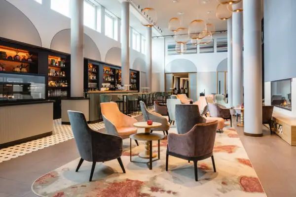 Die Bar im A-ROSA Hotel Sylt mit Stühlen und Tischen.