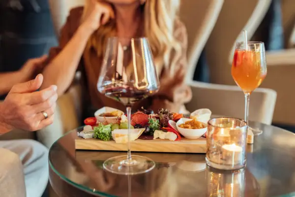 Ein Tisch mit Essen und Getränken, darunter Weingläser und Tischgeschirr.