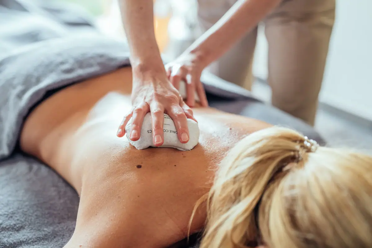 Eine Person gibt einer Frau eine Rückenmassage.
