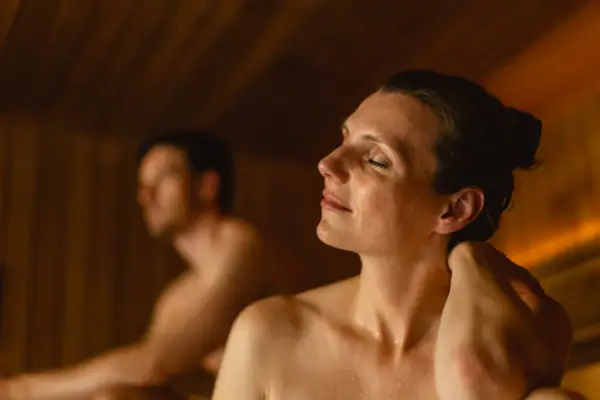 Eine Frau mit geschlossenen Augen in einer Sauna.