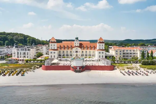 Großes Gebäude am Strand mit einem Gewässer im Vordergrund.