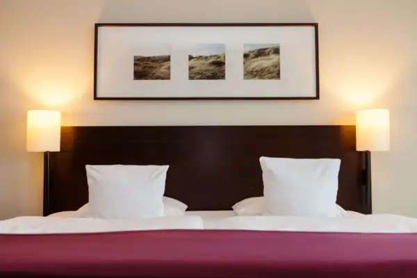 Ein Bett mit zwei Kissen und einem Bild an der Wand.