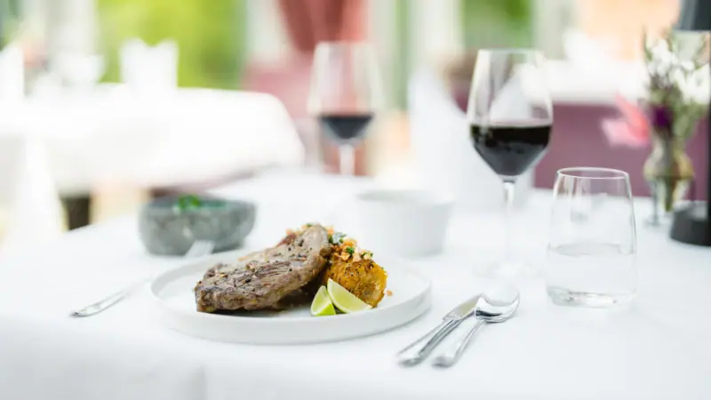 Ein Teller mit Essen und Weingläsern auf einem Tisch.