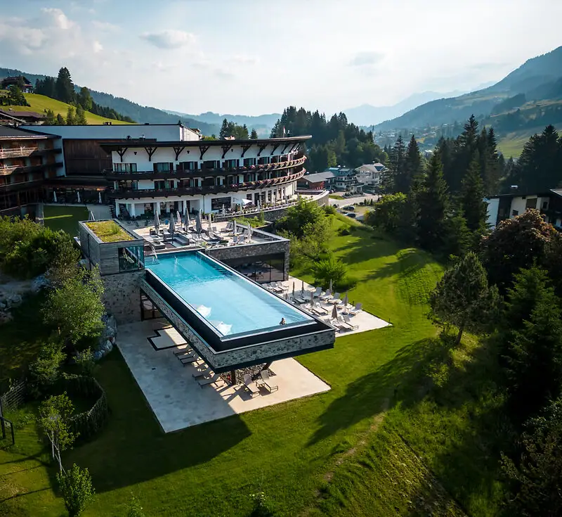Außenpool eines Hotels mit Blick auf Bäume und Himmel.