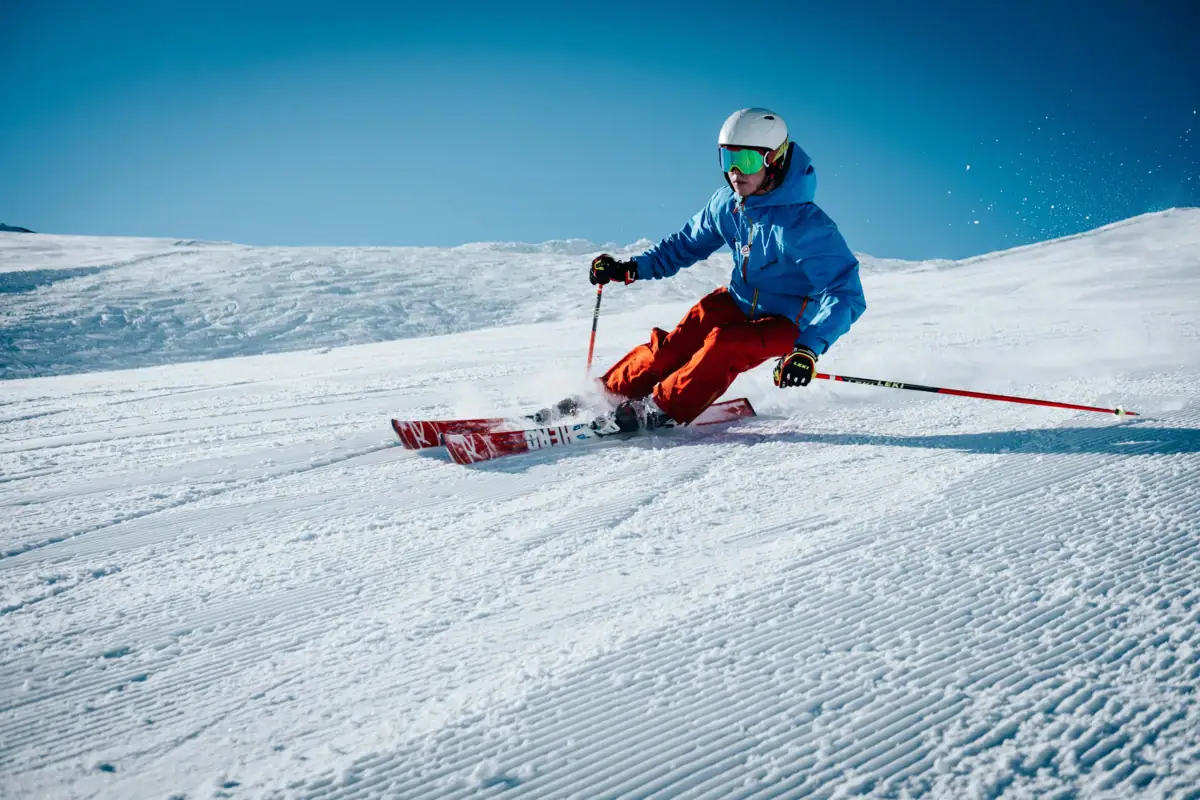 Person beim Skifahren auf einem verschneiten Hügel.