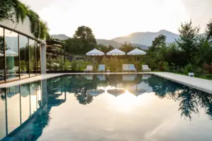 Ein Pool mit Stühlen und Sonnenschirmen im Hintergrund.