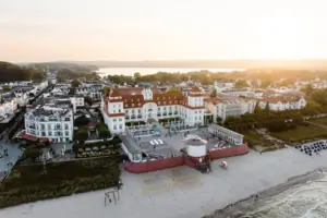 Strand mit Gebäuden und einem Gewässer im Hintergrund.