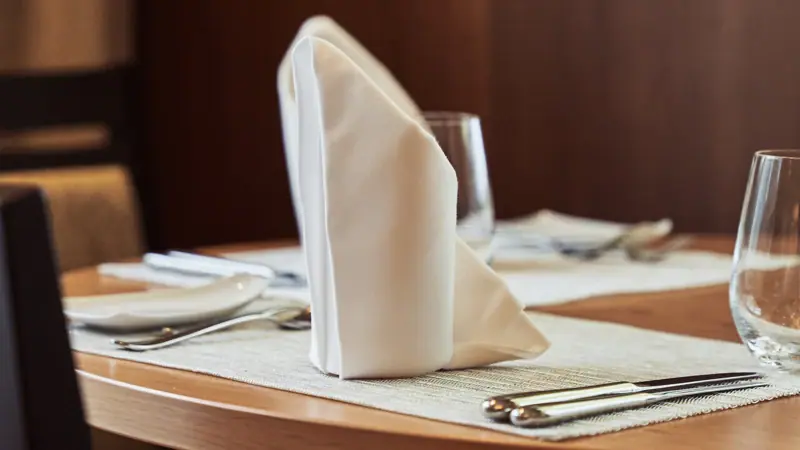 Ein Tisch mit Serviette und Gläsern.