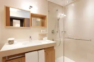 Badezimmer mit Glasdusche und Waschbecken