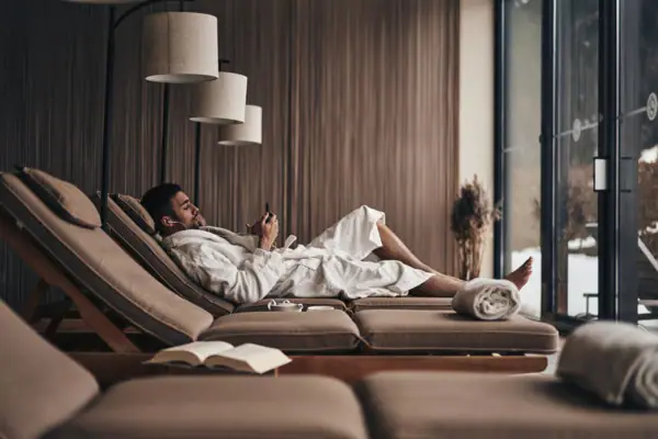 Ein Mann im Bademantel liegt auf einer Couch.