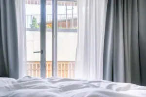 Ein Bett mit weißen Laken und Vorhängen.