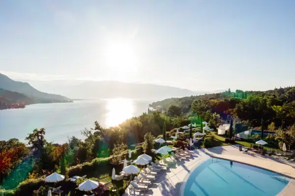 Gartenpool des A-ROSA Gardasee mit Liegen und Panoramablick auf den Gardasee