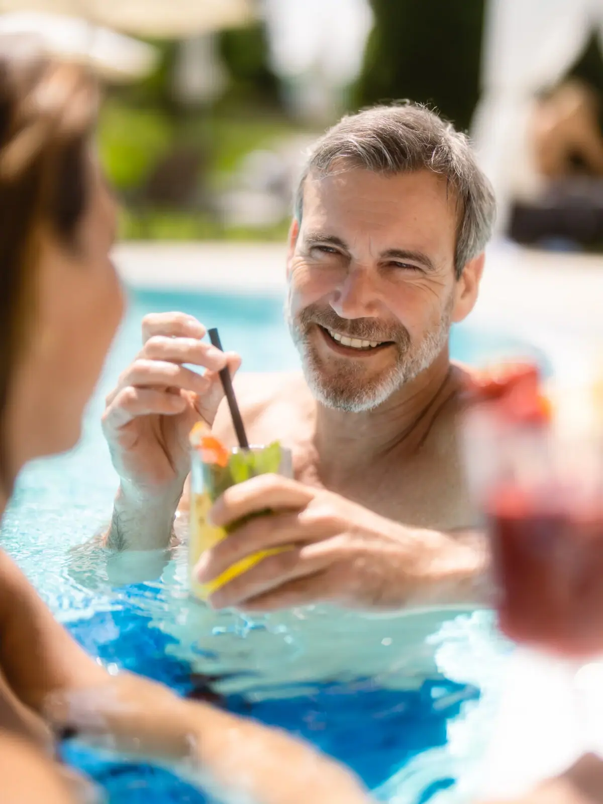 Ein Mann und eine Frau lächelnd im Schwimmbecken.
