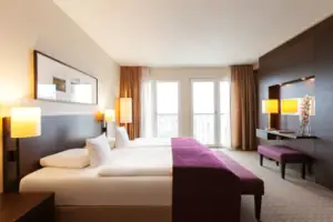 Schlafzimmer mit lila Bett und lila Stuhl