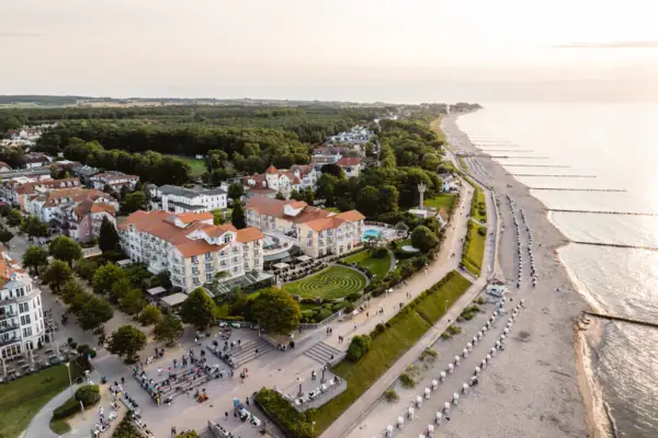 Strand mit Gebäuden und Bäumen im Hintergrund.