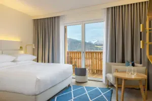Ein Hotelzimmer mit einem Bett, einem Teppich und einem Stuhl.