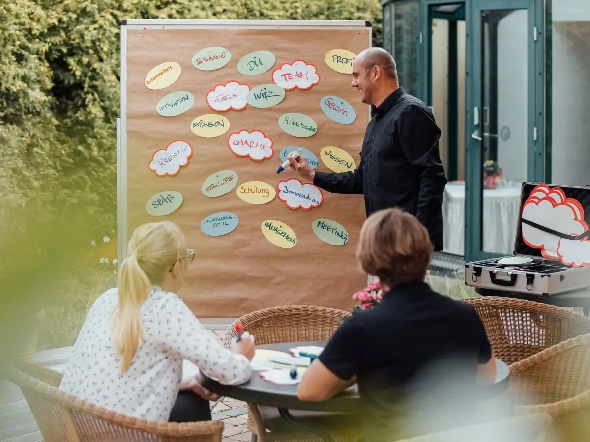 Ein Mann schreibt auf eine Tafel.